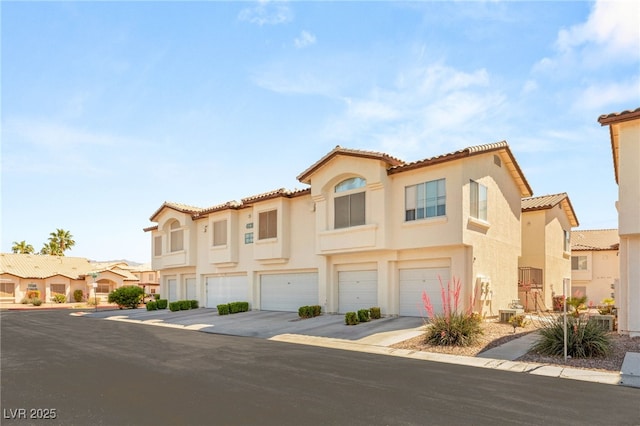 4830 Grey Wolf Ln Unit 104, Las Vegas, NV 89149 - view of front of home featuring a garage, driveway, stucco siding, and a tiled roof