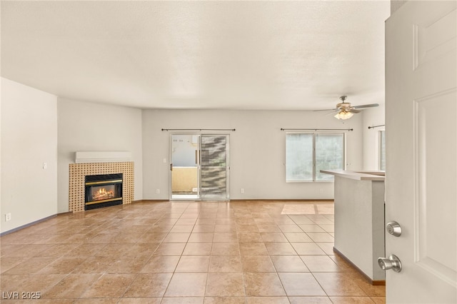 4830 Grey Wolf Ln Unit 104, Las Vegas, NV 89149 - unfurnished living room with a fireplace, ceiling fan, light tile patterned floors, and baseboards