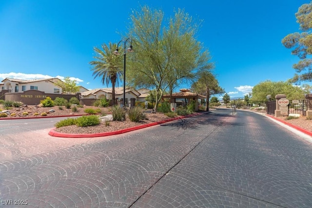 4830 Grey Wolf Ln Unit 104, Las Vegas, NV 89149 - view of road featuring curbs, a gate, a residential view, a gated entry, and street lights