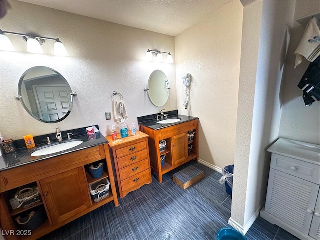 full bath featuring two vanities and baseboards
