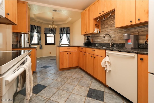 2822 La Palma Dr, Laughlin, NV 89029 - kitchen with white appliances, a raised ceiling, a chandelier, a peninsula, and a sink