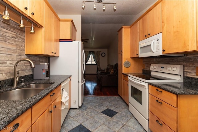 2822 La Palma Dr, Laughlin, NV 89029 - kitchen with white appliances, a sink, backsplash, and dark stone countertops