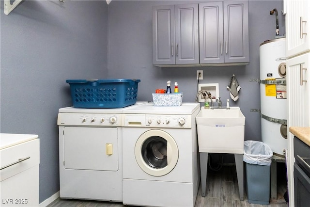 2822 La Palma Dr, Laughlin, NV 89029 - laundry area with washer and clothes dryer, light wood-style floors, cabinet space, baseboards, and water heater