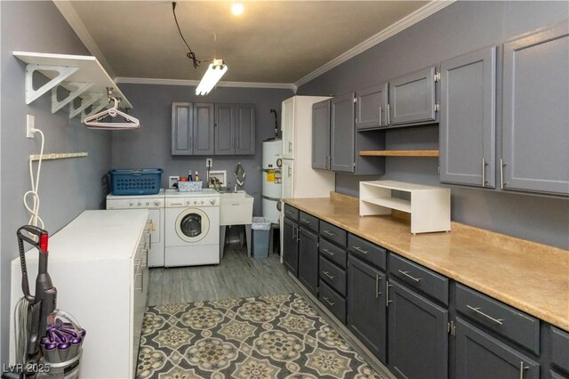 2822 La Palma Dr, Laughlin, NV 89029 - laundry room with cabinet space, washer and clothes dryer, ornamental molding, wood finished floors, and water heater