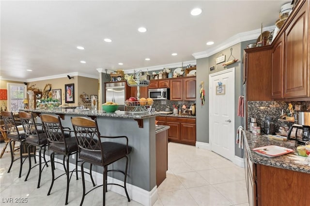 7301 Heggie Ave, Las Vegas, NV 89131 - kitchen featuring stainless steel appliances, crown molding, a breakfast bar area, backsplash, and dark stone counters