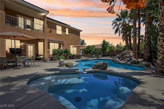 7301 Heggie Ave, Las Vegas, NV 89131 - pool at dusk featuring a patio and a pool with connected hot tub