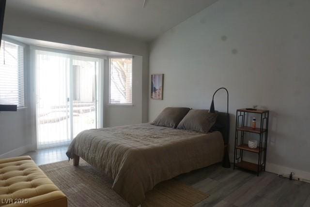 bedroom featuring wood finished floors, access to exterior, and baseboards