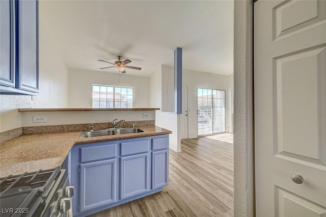 3318 N Decatur Blvd Unit 2129, Las Vegas, NV 89130 - kitchen featuring a sink, stainless steel range with gas cooktop, a ceiling fan, blue cabinets, and light wood-type flooring