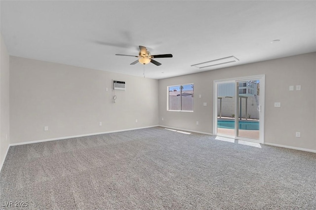 carpeted spare room with a ceiling fan, a wall unit AC, and baseboards