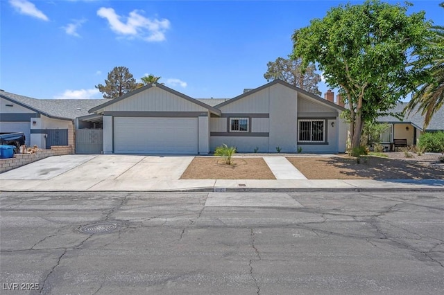 view of front of home featuring a garage, driveway, and fence