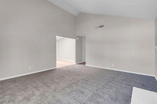 empty room featuring carpet, high vaulted ceiling, and baseboards