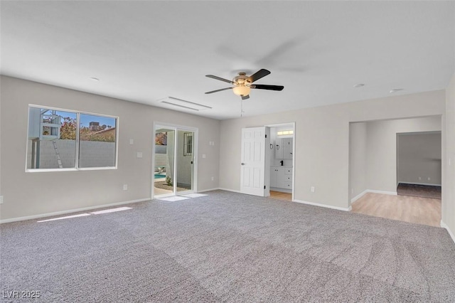 carpeted empty room featuring a ceiling fan and baseboards