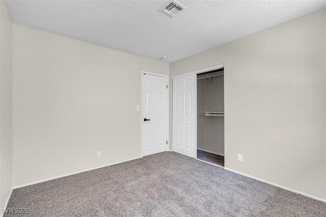 unfurnished bedroom featuring carpet flooring, a textured ceiling, baseboards, and a closet