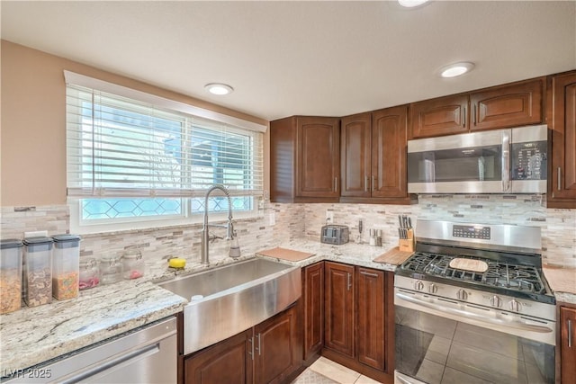 824 Schooner Dr, Henderson, NV 89015 - kitchen featuring appliances with stainless steel finishes, a sink, light stone counters, and decorative backsplash