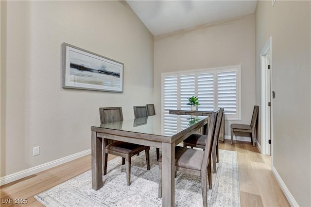 dining area with light wood-style flooring and baseboards