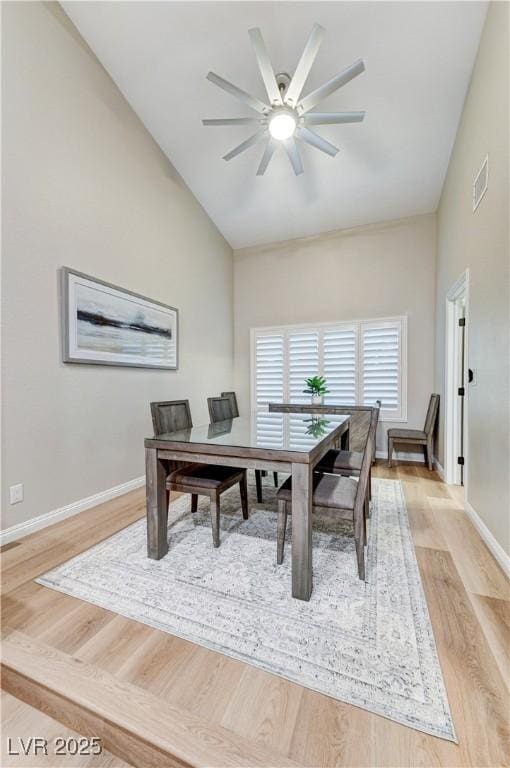 home office with light wood-style flooring, baseboards, ceiling fan, and high vaulted ceiling