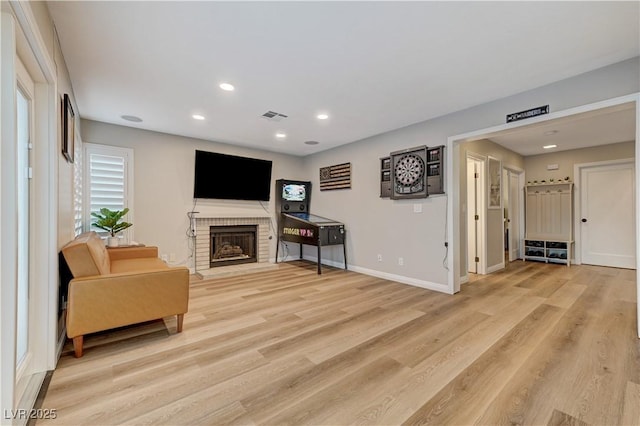 living room with a brick fireplace, light wood finished floors, recessed lighting, and baseboards