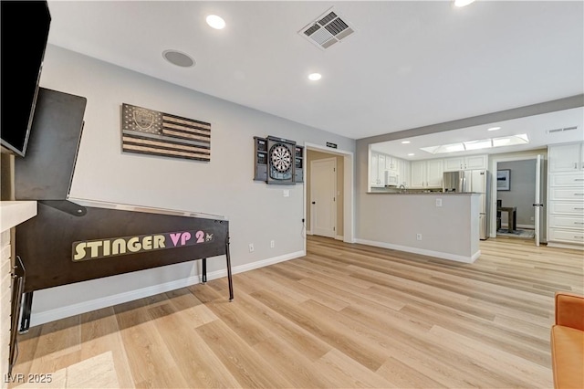 living area featuring light wood-style flooring, baseboards, and recessed lighting