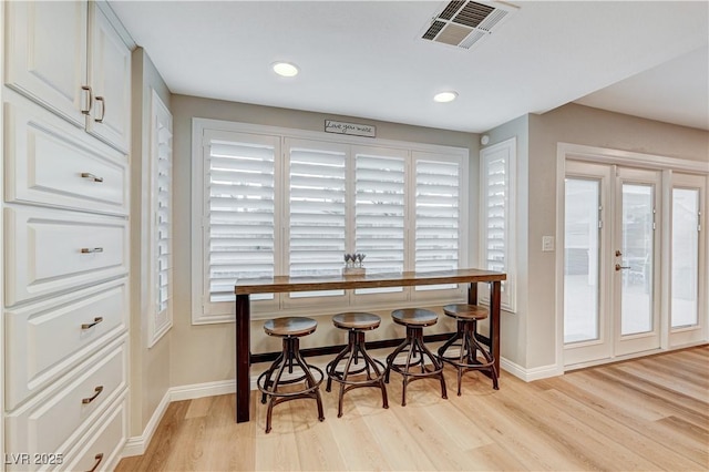 dining room with baseboards, light wood-style floors, plenty of natural light, and recessed lighting