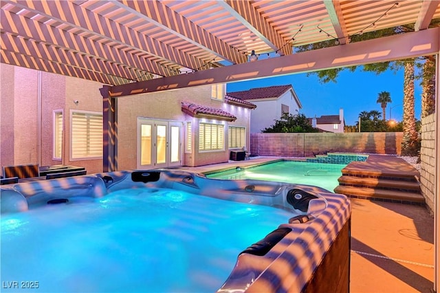view of swimming pool with a hot tub, french doors, and a fenced backyard
