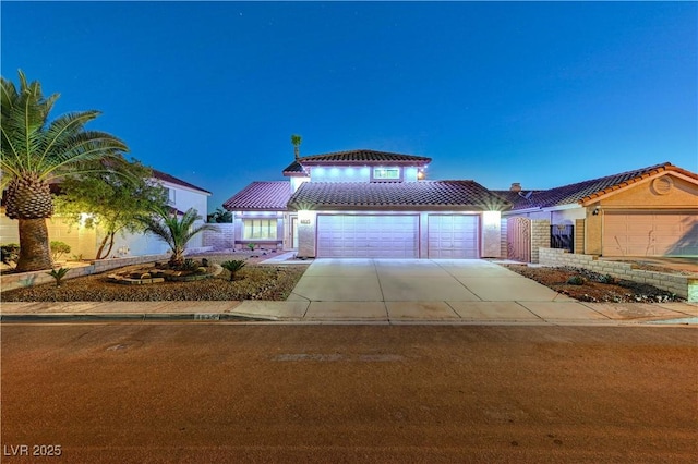 view of front of property featuring an attached garage, driveway, and a tiled roof