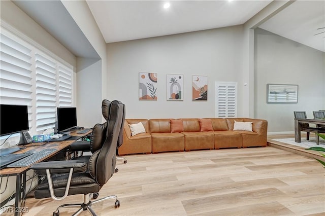 home office with wood finished floors, high vaulted ceiling, and baseboards