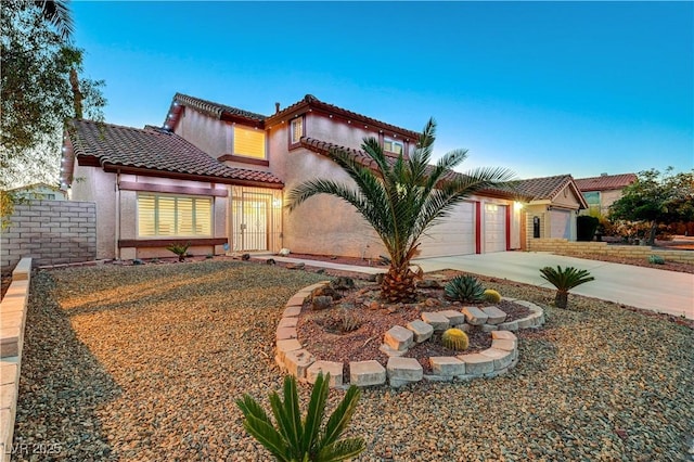 mediterranean / spanish-style house featuring a tile roof, driveway, and stucco siding