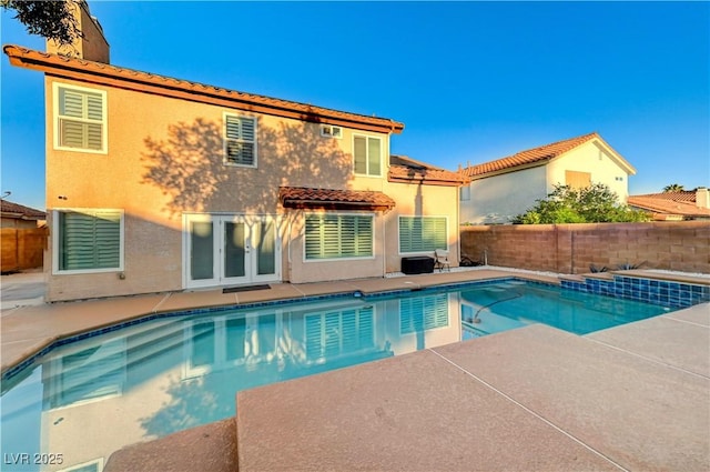 view of pool with a fenced backyard, a patio area, and french doors