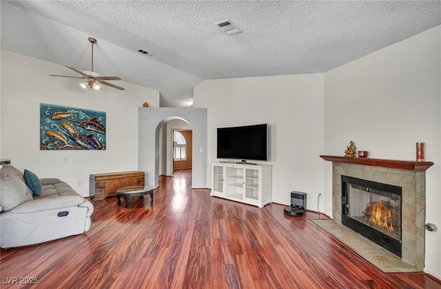 819 Arrowhead Trl, Henderson, NV 89002 - living room featuring wood finished floors, a ceiling fan, arched walkways, a fireplace, and lofted ceiling