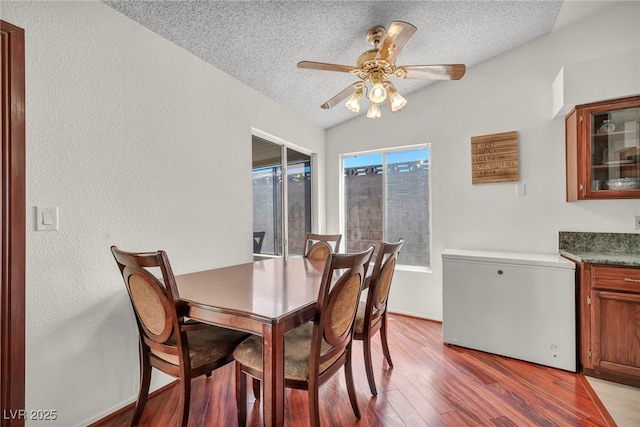 819 Arrowhead Trl, Henderson, NV 89002 - dining area featuring a textured ceiling, light wood-type flooring, a ceiling fan, a textured wall, and baseboards
