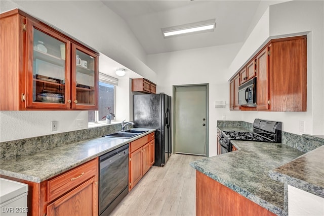 819 Arrowhead Trl, Henderson, NV 89002 - kitchen featuring black appliances, a sink, lofted ceiling, light wood finished floors, and glass insert cabinets