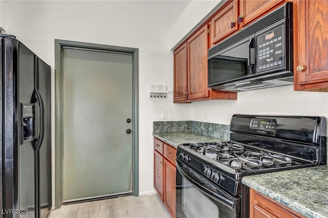 819 Arrowhead Trl, Henderson, NV 89002 - kitchen with black appliances, light wood-style flooring, and brown cabinets