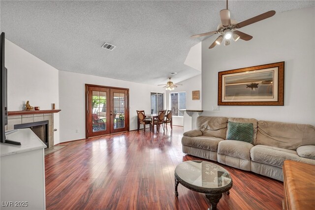 819 Arrowhead Trl, Henderson, NV 89002 - living area with a textured ceiling, vaulted ceiling, a ceiling fan, wood finished floors, and a tile fireplace