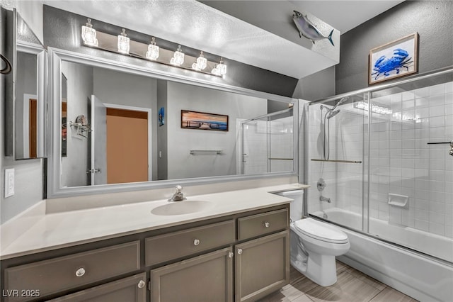 819 Arrowhead Trl, Henderson, NV 89002 - bathroom featuring vanity, toilet, bath / shower combo with glass door, and a textured wall