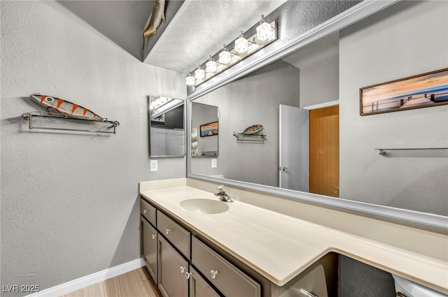 819 Arrowhead Trl, Henderson, NV 89002 - bathroom featuring baseboards, vanity, a textured wall, and wood finished floors