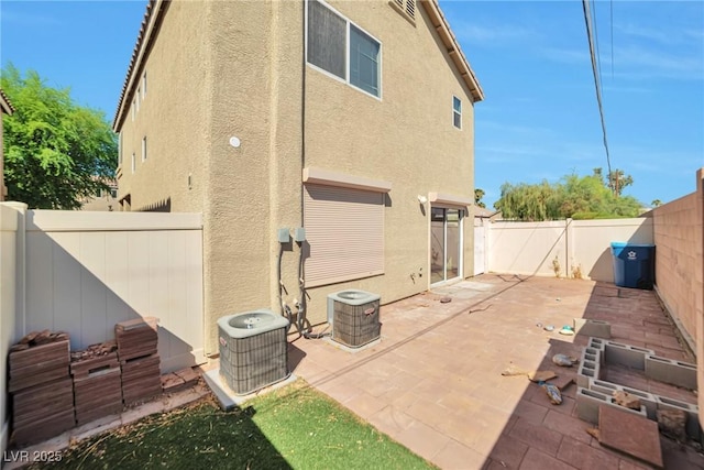 5740 Winter Cherry St, Las Vegas, NV 89130 - rear view of property with stucco siding, cooling unit, a patio area, and a fenced backyard