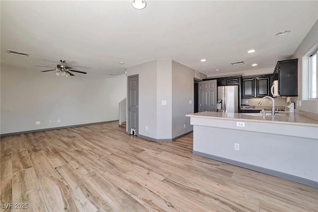 5740 Winter Cherry St, Las Vegas, NV 89130 - kitchen with stainless steel fridge, light countertops, light wood-style floors, ceiling fan, and recessed lighting