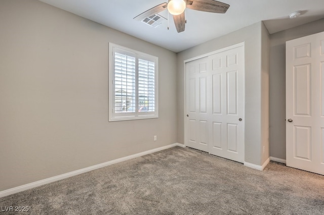 unfurnished bedroom featuring carpet flooring, a closet, baseboards, and a ceiling fan