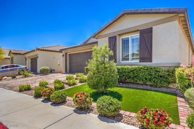 ranch-style home with a garage, stucco siding, a front lawn, driveway, and a tiled roof