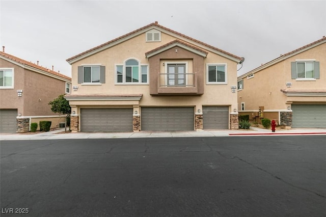 8675 Traveling Breeze Ave Unit 101, Las Vegas, NV 89178 - view of front of home with stucco siding, a garage, stone siding, and a balcony