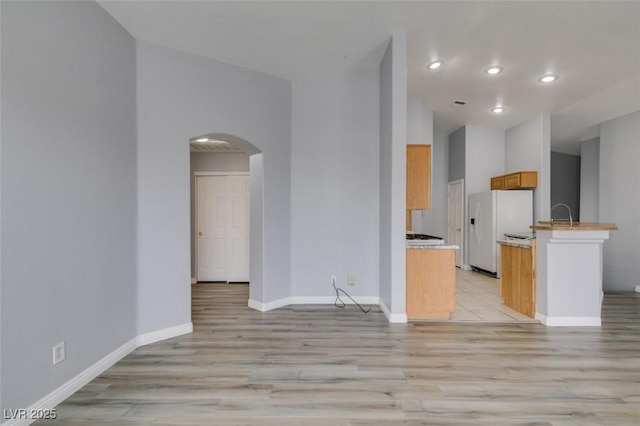 8675 Traveling Breeze Ave Unit 101, Las Vegas, NV 89178 - unfurnished living room with arched walkways, light wood-type flooring, recessed lighting, and baseboards