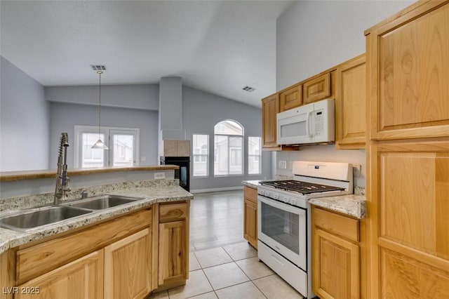 8675 Traveling Breeze Ave Unit 101, Las Vegas, NV 89178 - kitchen featuring white appliances, a sink, lofted ceiling, a tile fireplace, and light tile patterned floors