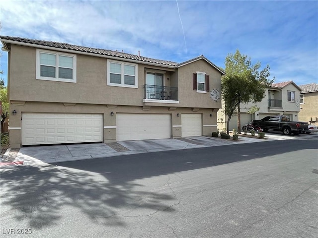6255 W Arby Ave Unit 239, Las Vegas, NV 89118 - view of property featuring stucco siding, a garage, and a tiled roof
