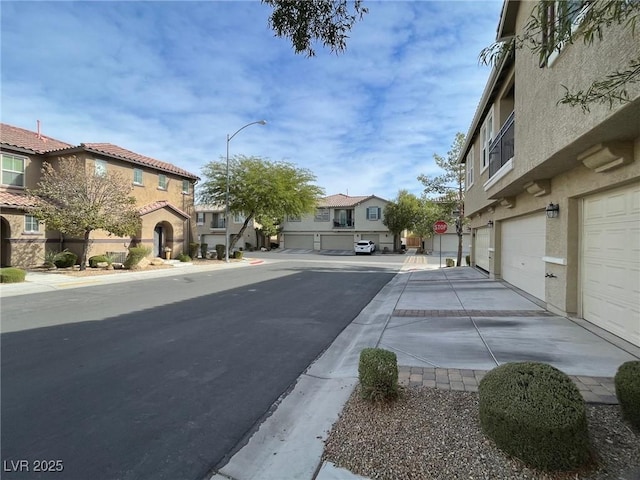 6255 W Arby Ave Unit 239, Las Vegas, NV 89118 - view of asphalt road with a residential view, sidewalks, street lights, traffic signs, and curbs