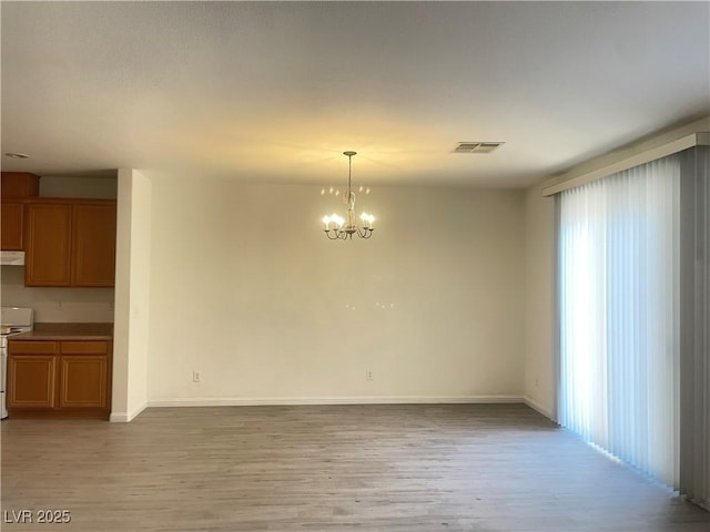 6255 W Arby Ave Unit 239, Las Vegas, NV 89118 - unfurnished dining area with a chandelier, light wood finished floors, and baseboards