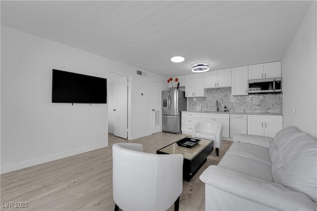 living room featuring light wood-type flooring and baseboards