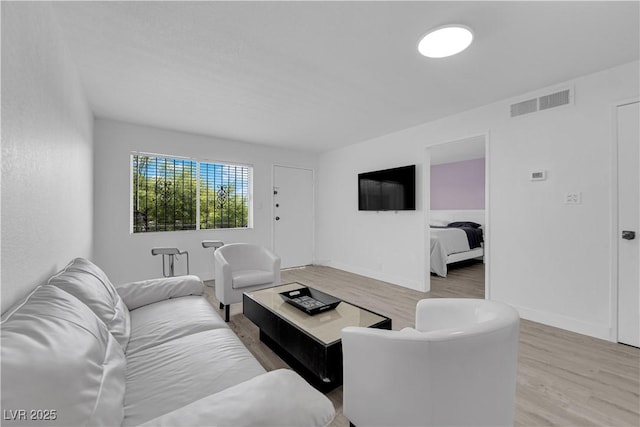 living area featuring light wood-style flooring and baseboards