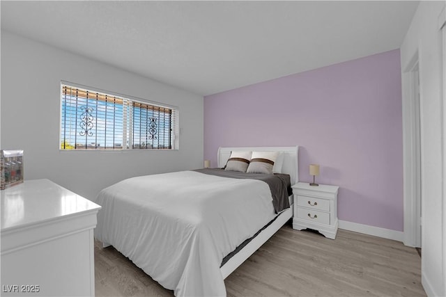 bedroom with light wood-style flooring and baseboards