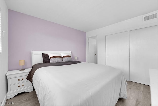 bedroom featuring light wood finished floors and a closet
