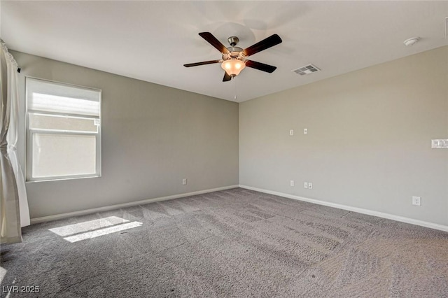 carpeted spare room with a ceiling fan, baseboards, and a smoke detector